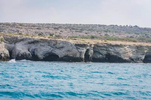 Small backwater surrounded by a stone cliff with azure water in Cyprus Stock Photos
