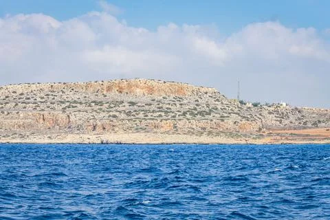 Small backwater surrounded by a stone cliff with azure water in Cyprus Foto stock