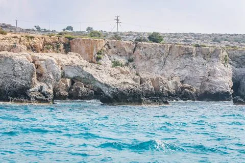 Small backwater surrounded by a stone cliff with azure water in Cyprus Stock Photos