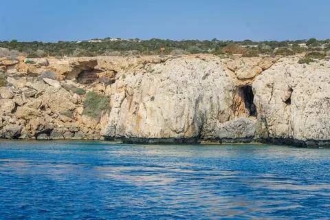Small backwater surrounded by a stone cliff with azure water in Cyprus Stock Photos