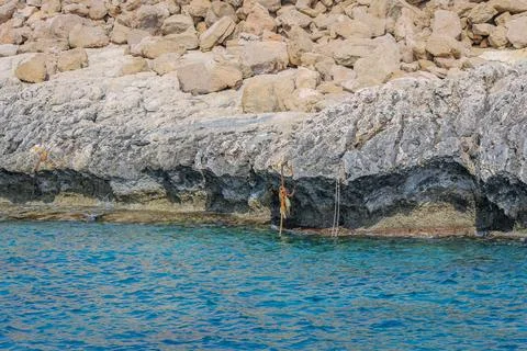 Small backwater surrounded by a stone cliff with azure water in Cyprus Foto stock