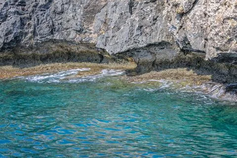 Small backwater surrounded by a stone cliff with azure water in Cyprus Stock Photos