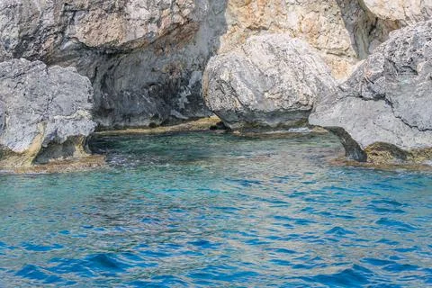 Small backwater surrounded by a stone cliff with azure water in Cyprus Stock Photos