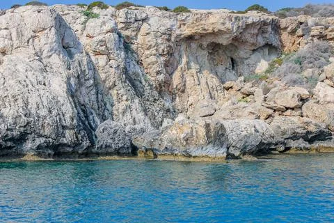 Small backwater surrounded by a stone cliff with azure water in Cyprus Stock Photos