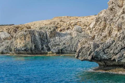 Small backwater surrounded by a stone cliff with azure water in Cyprus Stock Photos