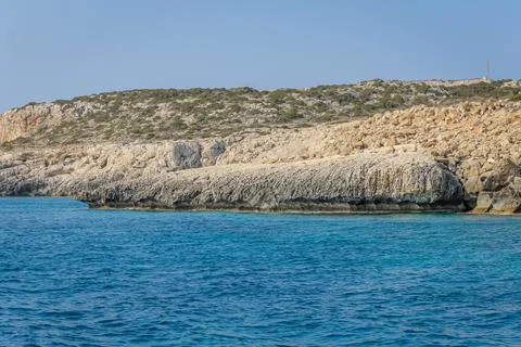 Small backwater surrounded by a stone cliff with azure water in Cyprus Stock Photos