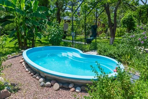 Small Backyard Swimming Pool in Lush Garden Stock Photos