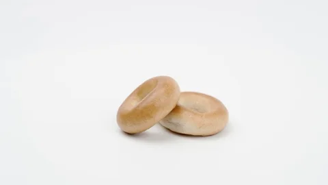 Small bagels drying on a white background. Rotation. Видео 129026481
