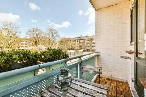 A small balcony with a table and a vase Stock Photos