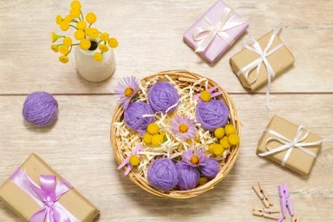 Small balls of thread in a basket. Gift boxes. Clothespins Fotos de archivo