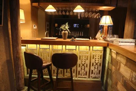 A small bar with two high chairs, the backrests of which have carved patter.. Stock Photos