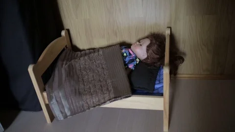 Small Barbie Doll sleeps in a Small Toy Bed Stock Footage 99377457