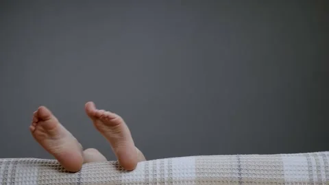 Small bare legs kids in sofa child. Kid waving funny foot comfort home boy Stock Footage 152495699