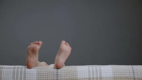 Small bare legs kids in sofa child close up toes. Kid waving funny foot comfort Stock Footage 152495904
