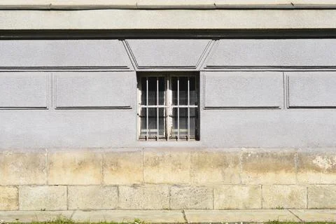 Small basement window with iron bars on old building facade Stock Photos