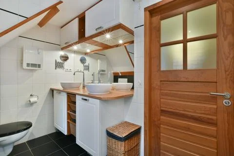 A small bathroom with two sinks and a toilet Stock Photos