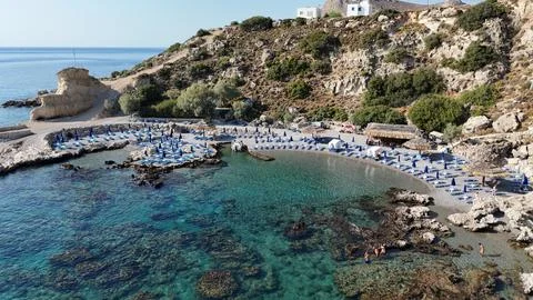 Small Beach with Rocky Cliffs and Turquoise Water from Drone 스톡 사진