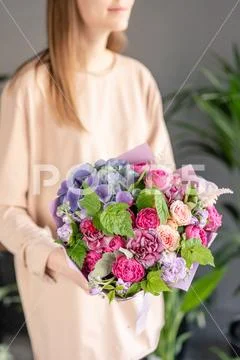 Small Beautiful bouquet of mixed flowers in woman hand. Floral shop concept Stock Photos