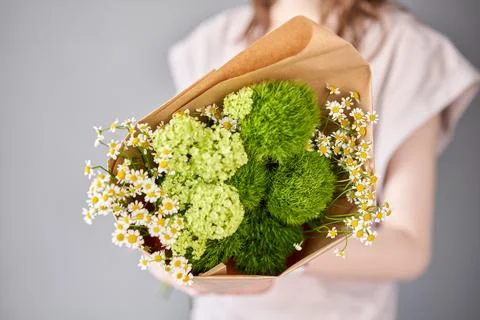 Small Beautiful bouquets of mixed flowers in woman hand. Floral shop concept Stock Photos