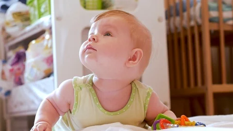 A Small Beautiful Toddler Pushes Herself Up Stock Footage 91699314