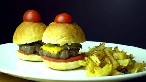 Small beef burgers with cereals bread, melted cheese, vegetables, french fries Stock Footage 69841315