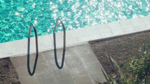 Small bird hanging out at the pool. Light ripples and sun glare on turquoise Stock Footage 154713202