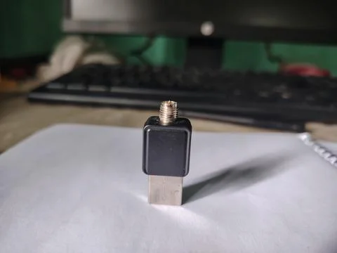 Small black and silver USB device with gold connector on white paper in fro.. Fotos Stock