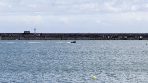 Small black boat crossing harbor panning Stock Footage 336505782