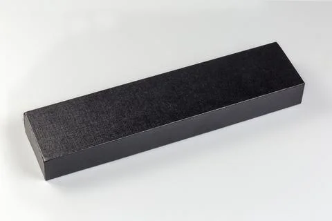Small black long rectangular cardboard box with closed lid Фото