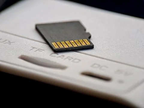A small, black memory card rests on a white surface, its golden pins catchi.. Stock Photos