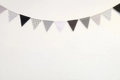 Small black white triangle shape flag hanging curve down plaster wall Stockfoto's