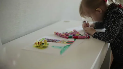 A small blond girl drawing two pictures at the same time. Slow motion Stock Footage 62793269