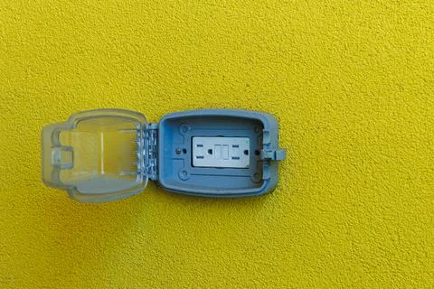 Small blue case with latch opened on yellow background showing a gray devic.. Фото