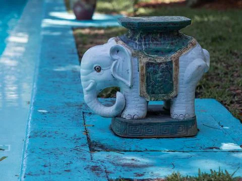 A small blue ceramic elephant statue by the pool. Stock Photos