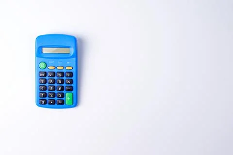 Small blue plastic calculator on a white background. Isolate. Copy space. Fla Stock Photos