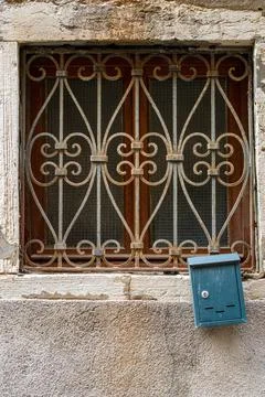 Small blue postbox Close-up of a window secured with solid bars and a smal... Stockfoto's