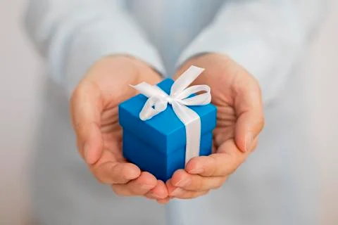 Small blue present box in hands Stock Photos