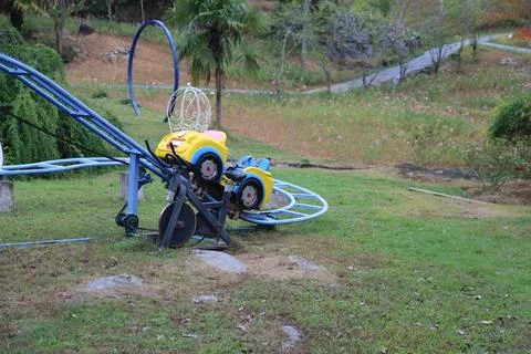 Small blue roller coaster track on a grassy hill Stock Photos
