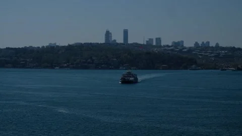 Small Boat Approaching on Gentle Waves with Cityscape Background – Urban Sea Video stock 303868168