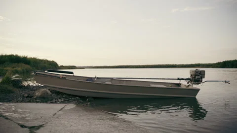 Small boat beached in river at sunset Stock Footage 254981472