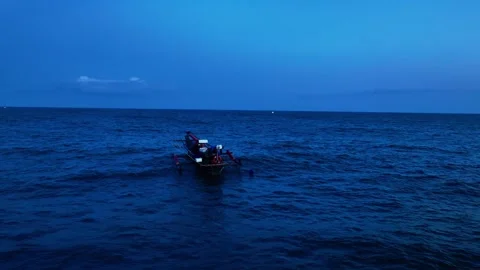 Small boat on blue ocean at dusk Vídeo Stock 335440893