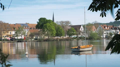 A small boat is on a calm river. During sunset. In a city park in Europe Stock Footage 272620427