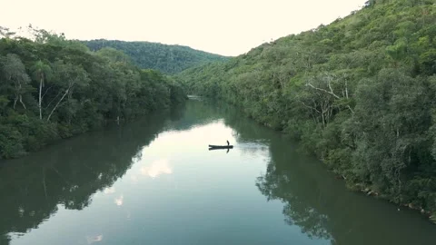 A small boat crossing a river. Canoe. Forest. Drone footage. Video stock 332260665