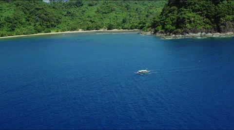 Small boat in deep blue ocean along mountainous coastline Video stock 25359694