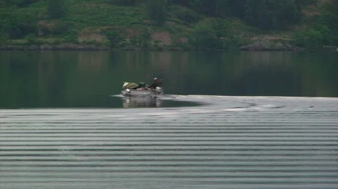 Small boat draws a wake on still water lake Stock Footage 39987593