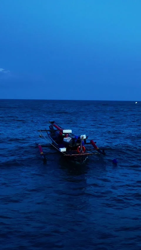 Small boat drifting on blue evening ocean Vídeo Stock 335433055