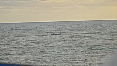 Small Boat Floating Alone in Open Sea at Tropical Sunset Stock Footage 296570226