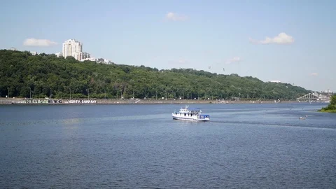 A small boat floats on the river. Dnipro River Stock Footage 129114566