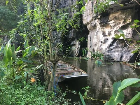 Small Boat Hidden Behind Trees, Resting On A Lake - Ninh Binh, Vietnam Stock Photos