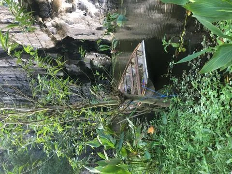 Small Boat Hidden Behind Trees, Resting On A Lake - Ninh Binh, Vietnam Stock Photos